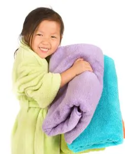 Young girl in bathrobe with towels