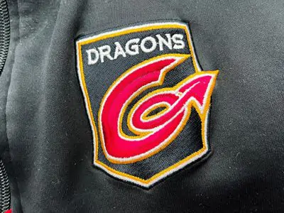 Embroidered black and red Dragons logo on coat
