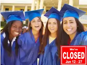 Four girls in blue graduation gowns smiling for the camera